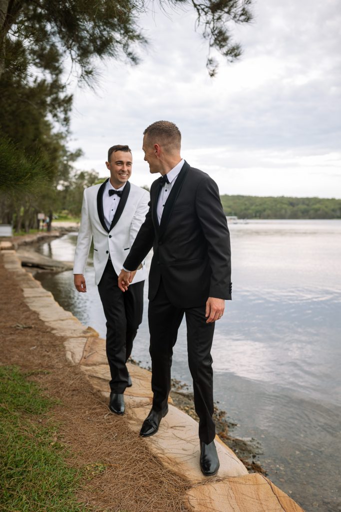 husband and husband holding hands at raffertys resort during the groom photo shoot