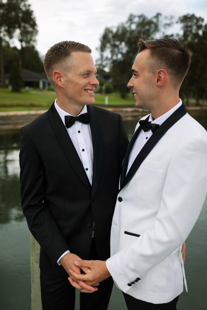 husband and husband holding hands at raffertys resort during the groom photo shoot