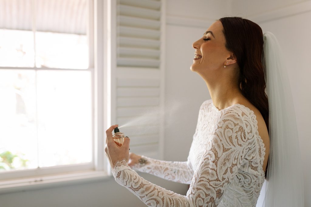 Bride putting perfume on during prep at her wedding in the hunter valley