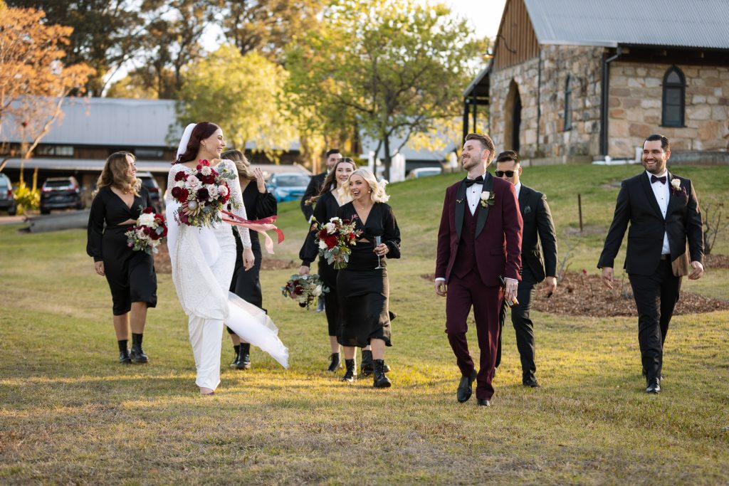 bride and groom with their bridal party walking on location photos at their wedding in the hunter valley