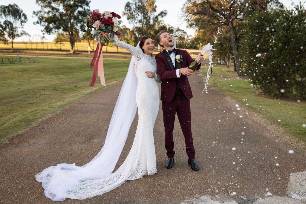 Husband and wife or bride and groom spray champaign in the hunter valley at their wedding