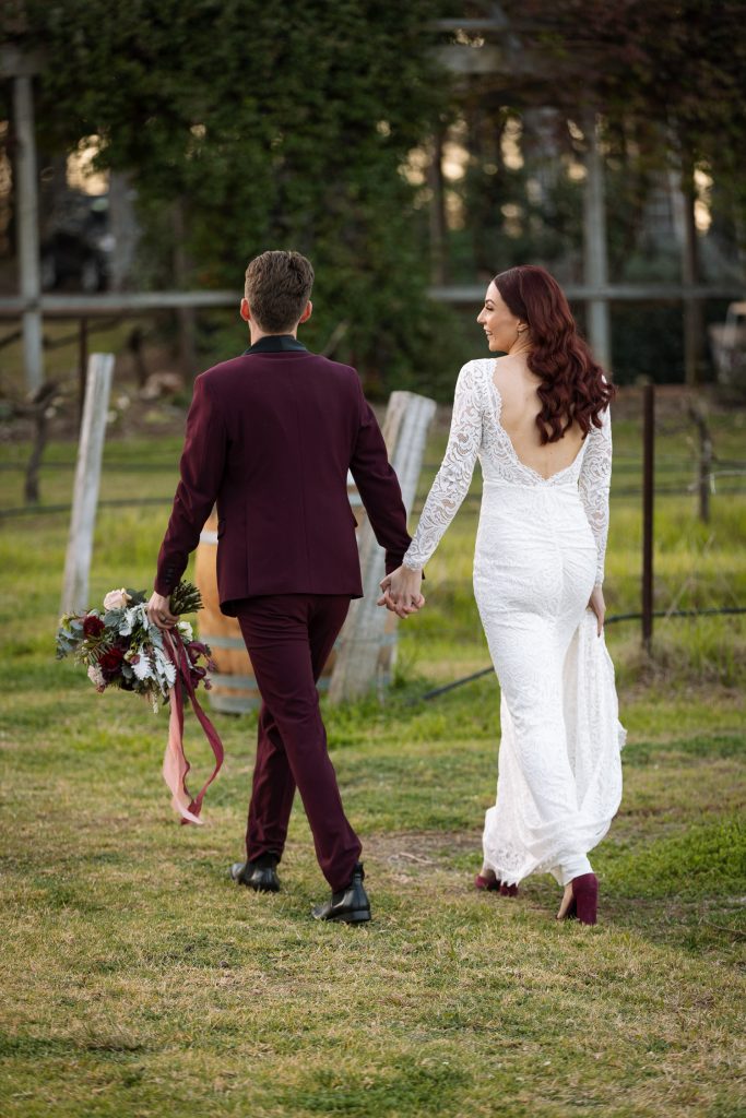 bride and groom location photos whilst walking at their wedding in the hunter valley. Back of brides dress