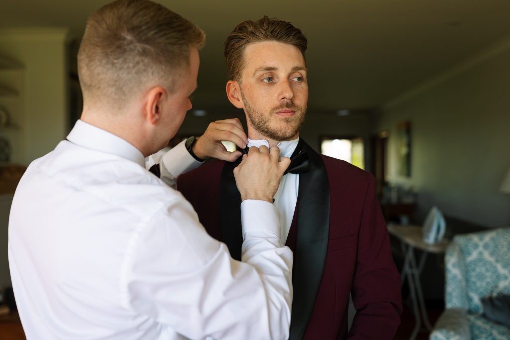 Groom getting ready with accessories during prep at his wedding in the hunter valley
