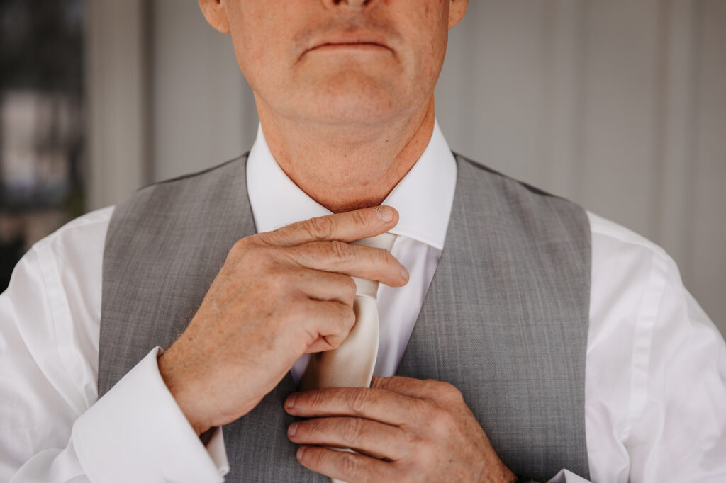 timing the knot of a tie at a wedding