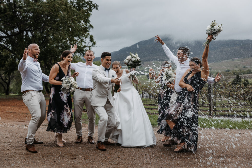 bridal party popping the bottle of bubbles
