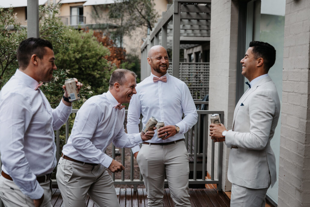 groomsmen celebrate whilst waiting for the bride