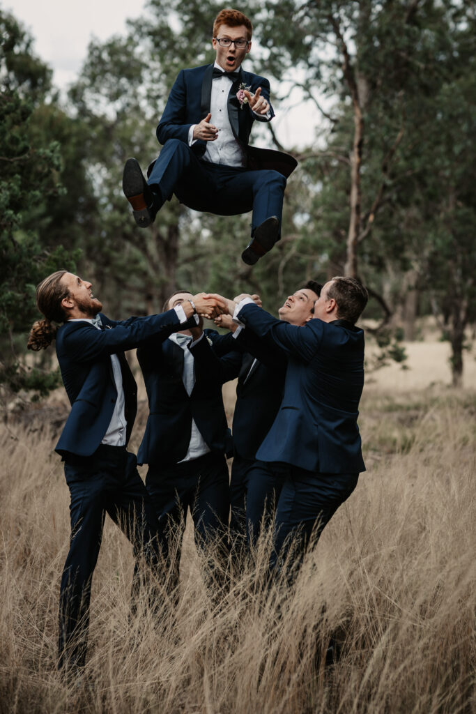 Groom being thrown in the air by groomsmen on a location shoot Wagga Wagga