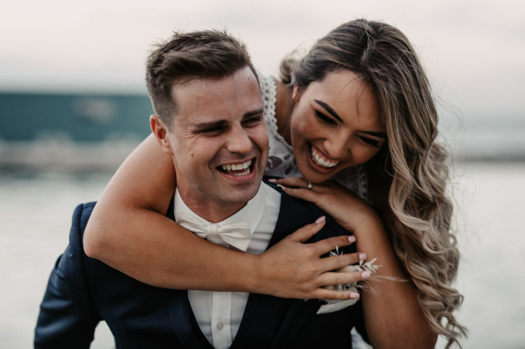 bride and groom piggy back