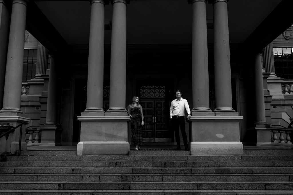 couple standing on the steps at custom house in Newcastle on their engagement session