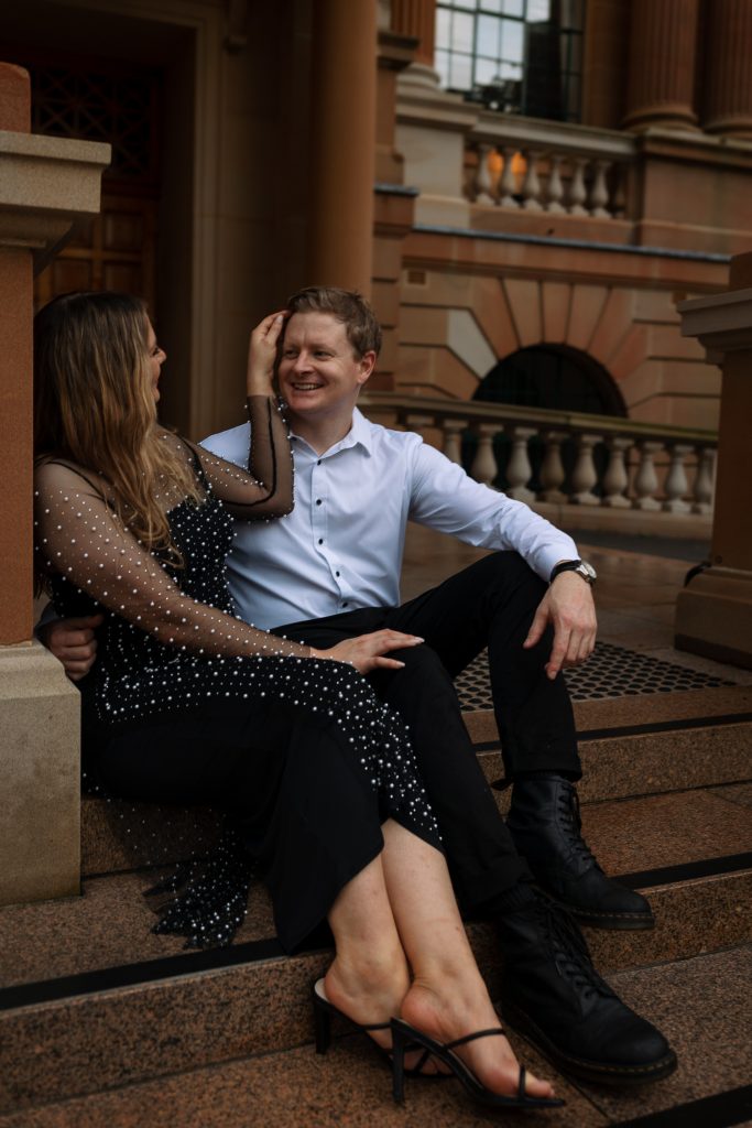 couple kissing on the steps at custom house in Newcastle on their engagement session