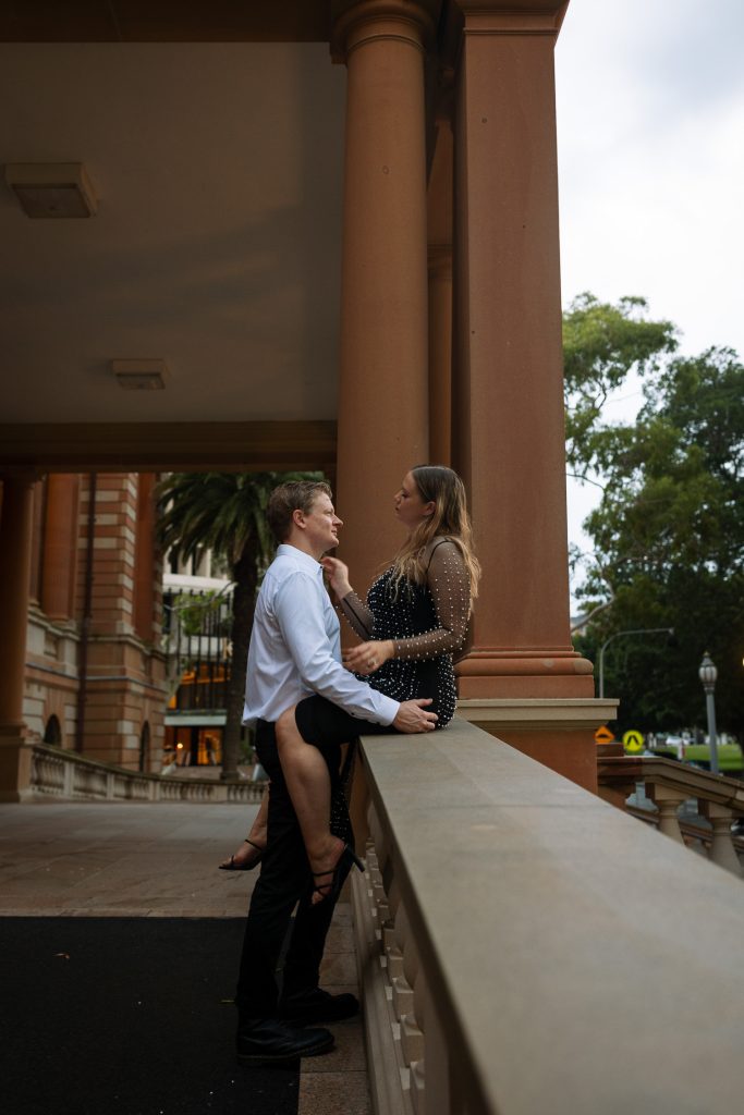 couple kissing on the steps at custom house in Newcastle on their engagement session