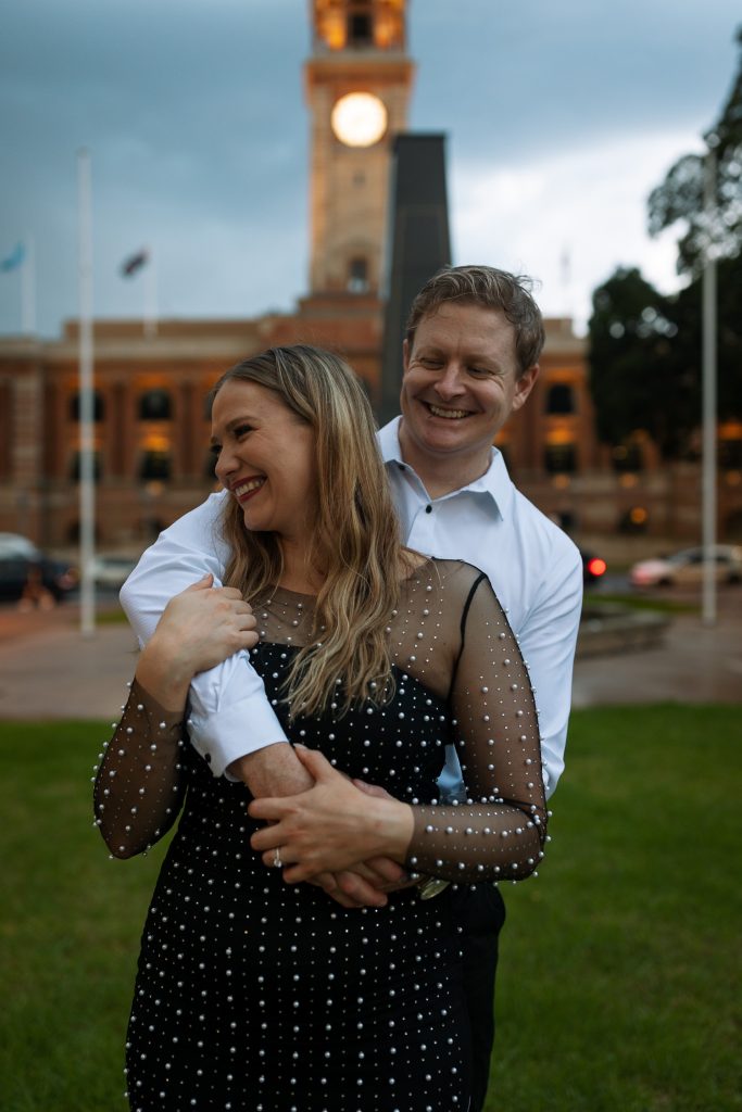 couple kissing in front of custom house in Newcastle on their engagement session