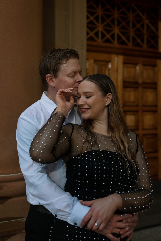 couple kissing at custom house in Newcastle on their engagement session