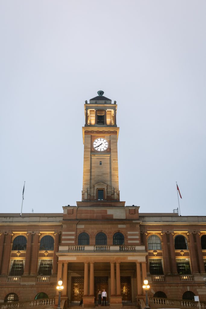 couple outside on the steps at custom house in Newcastle on their engagement session