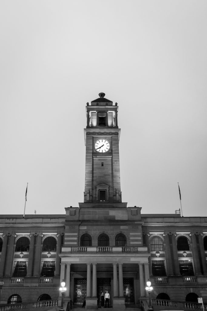 couple outside on the steps at custom house in Newcastle on their engagement session