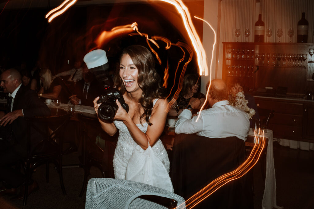 Bride taking a photo at the reception