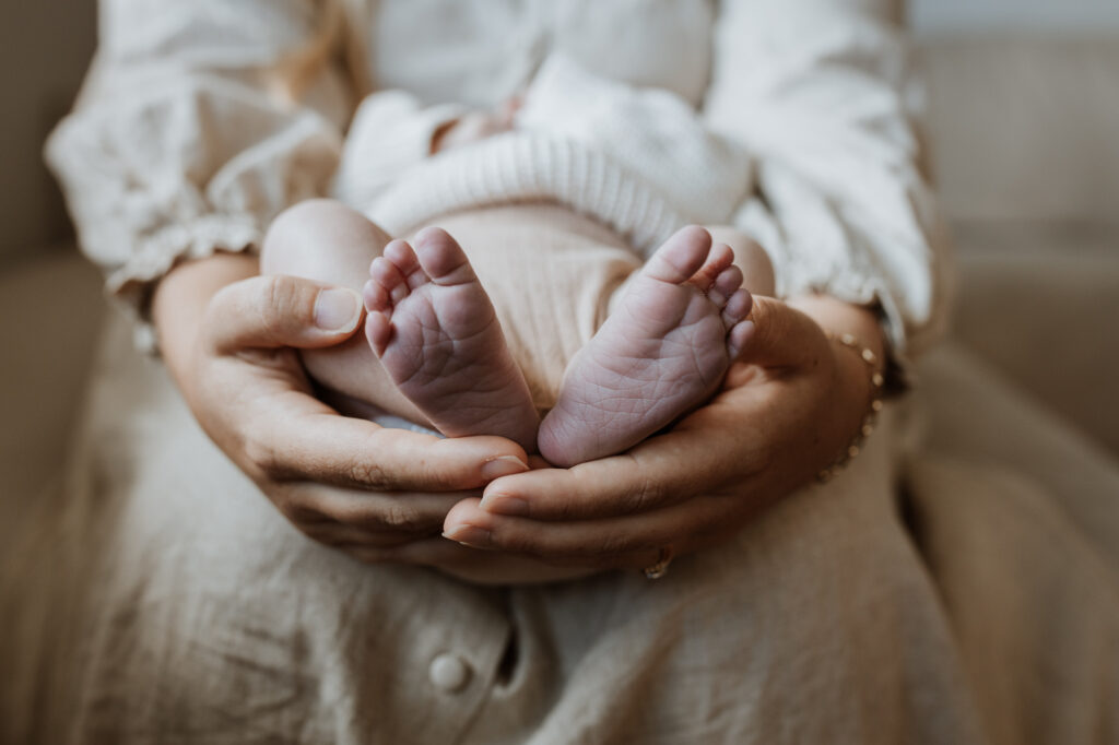 babies feet in mummy's hands