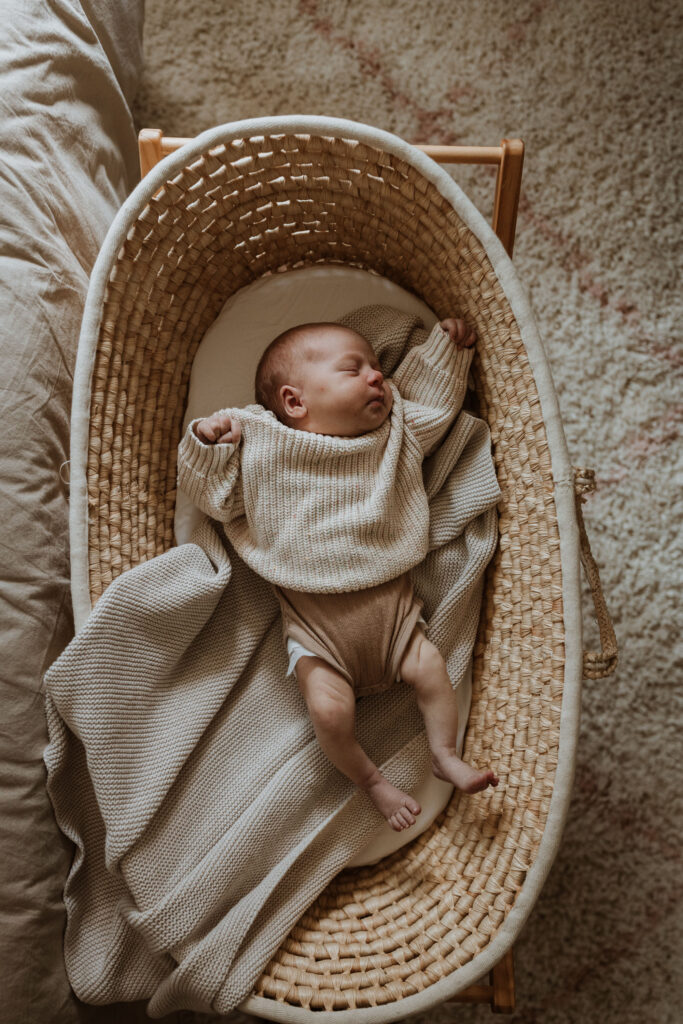 baby in crib or basket going to sleep with blanket