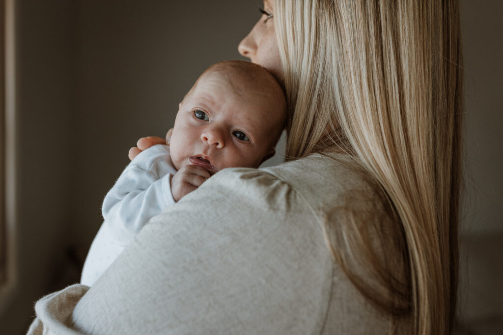 baby and mum cuddling by the window
