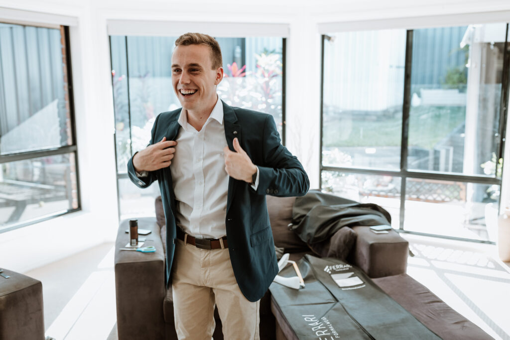 groomsmen getting ready at the grooms house. Putting shirts and jackets on
