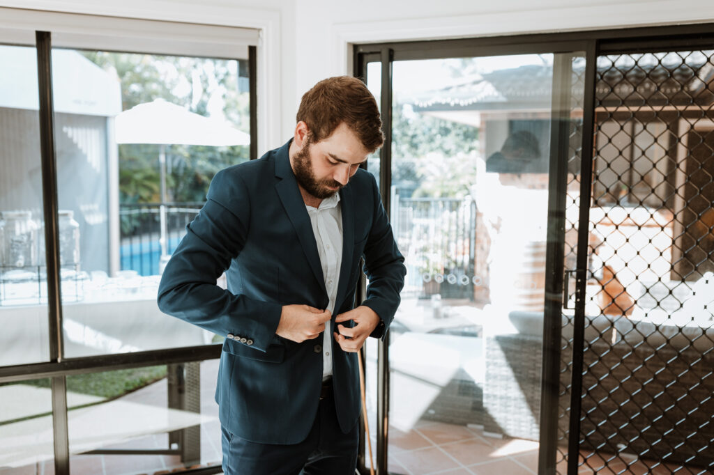 groomsmen getting ready at the grooms house. Putting shirts and jackets on