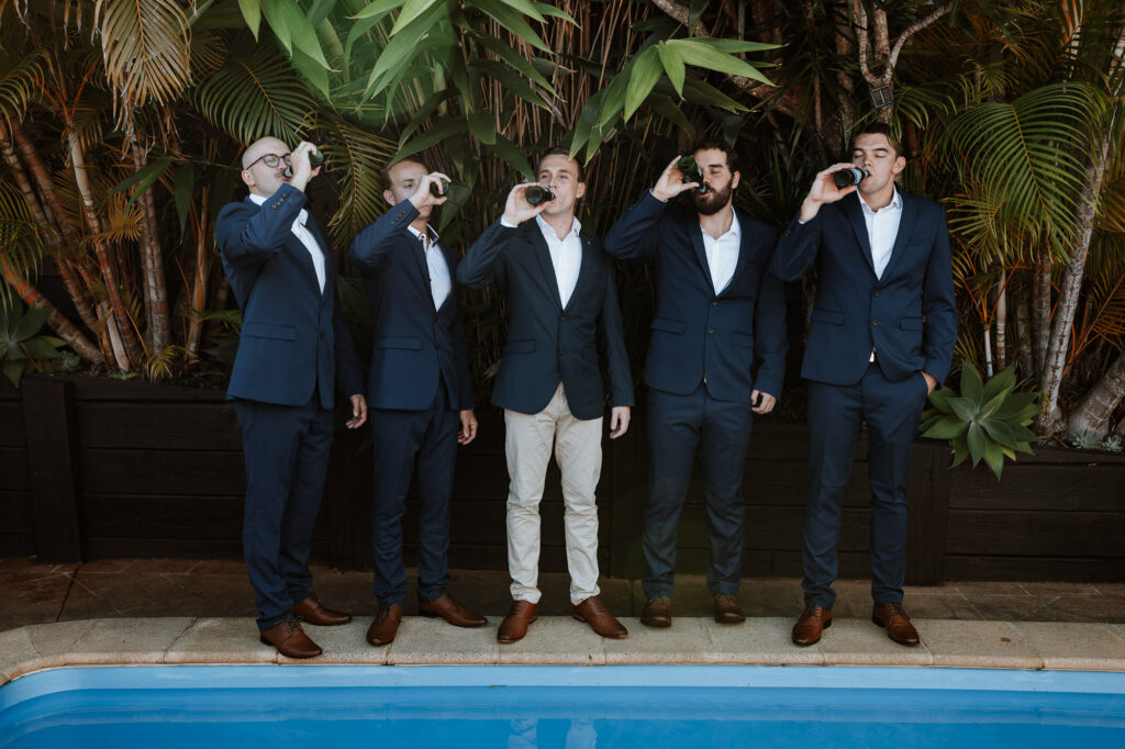 groomsmen outside drinking and celebrating whilst getting ready. Pre Ceremony photos.