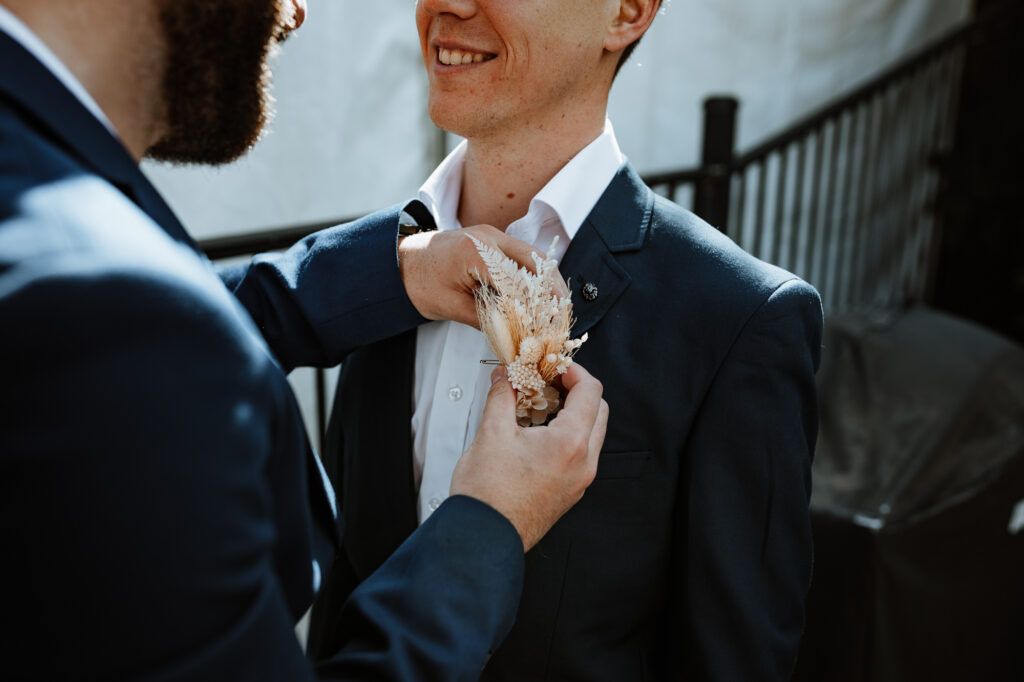 Groomsmen putting on boutonnière