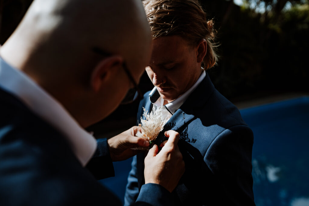 Groomsmen putting on boutonnière