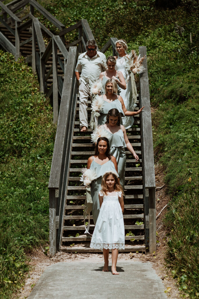 wedding party walking down to the beach down the wooden stairs in port Macquarie