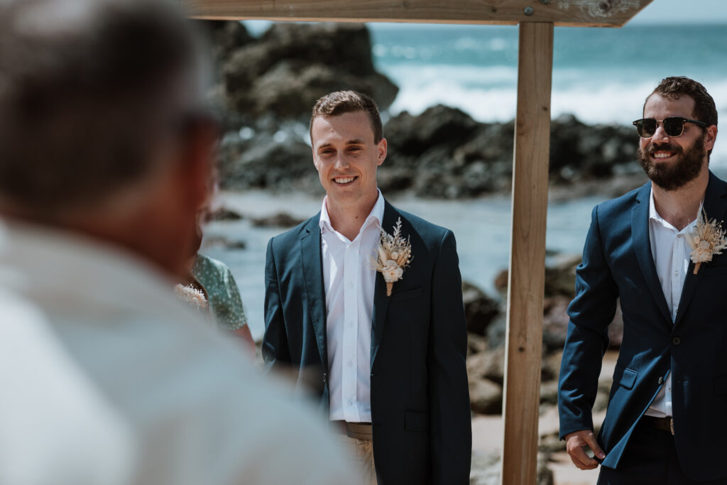 groom looking at his future bride walking down the isle with her dad