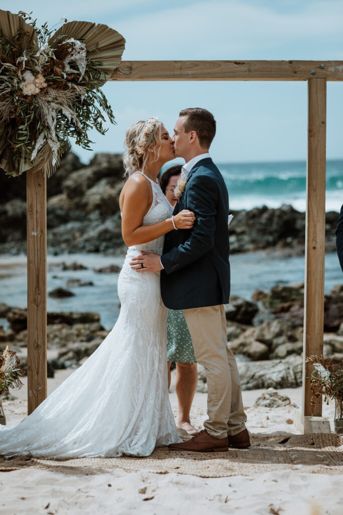 first kiss with husband and wife under the alter at he beach in Port Macquarie