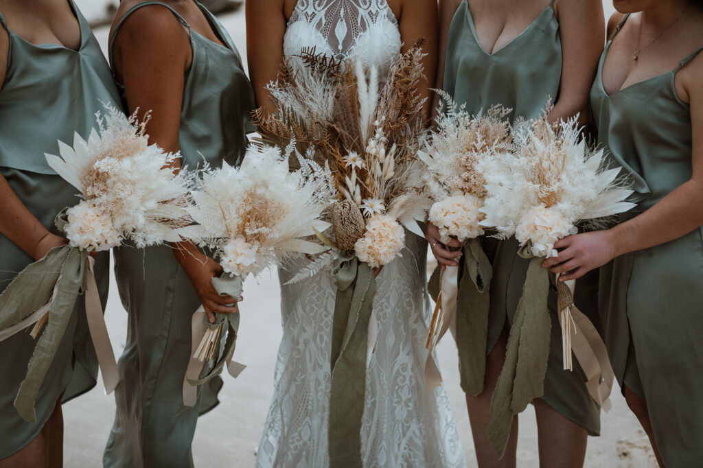 husband and wife photo shoot on the beach in Port Macquarie with the bridal party and their dried flowers
