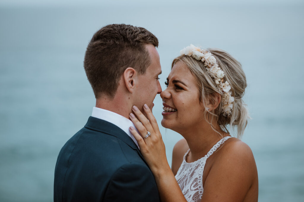 husband giving wife a kiss and lifting her up by the lighthouse in Port Macquarie