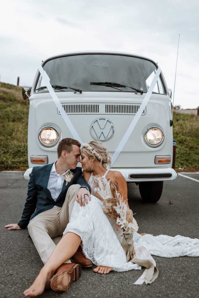 husband giving wife a kiss and lifting her up by the lighthouse in Port Macquarie next to the combo wedding car