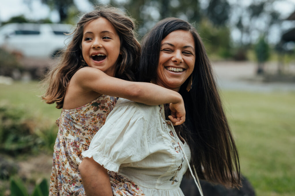 mum giving daughter piggy back