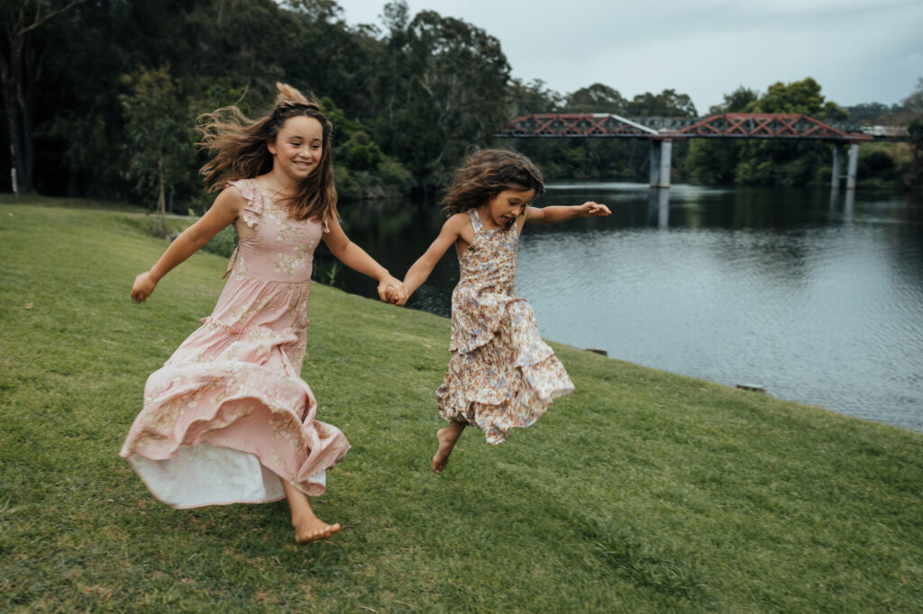 sisters running whilst holding hands
