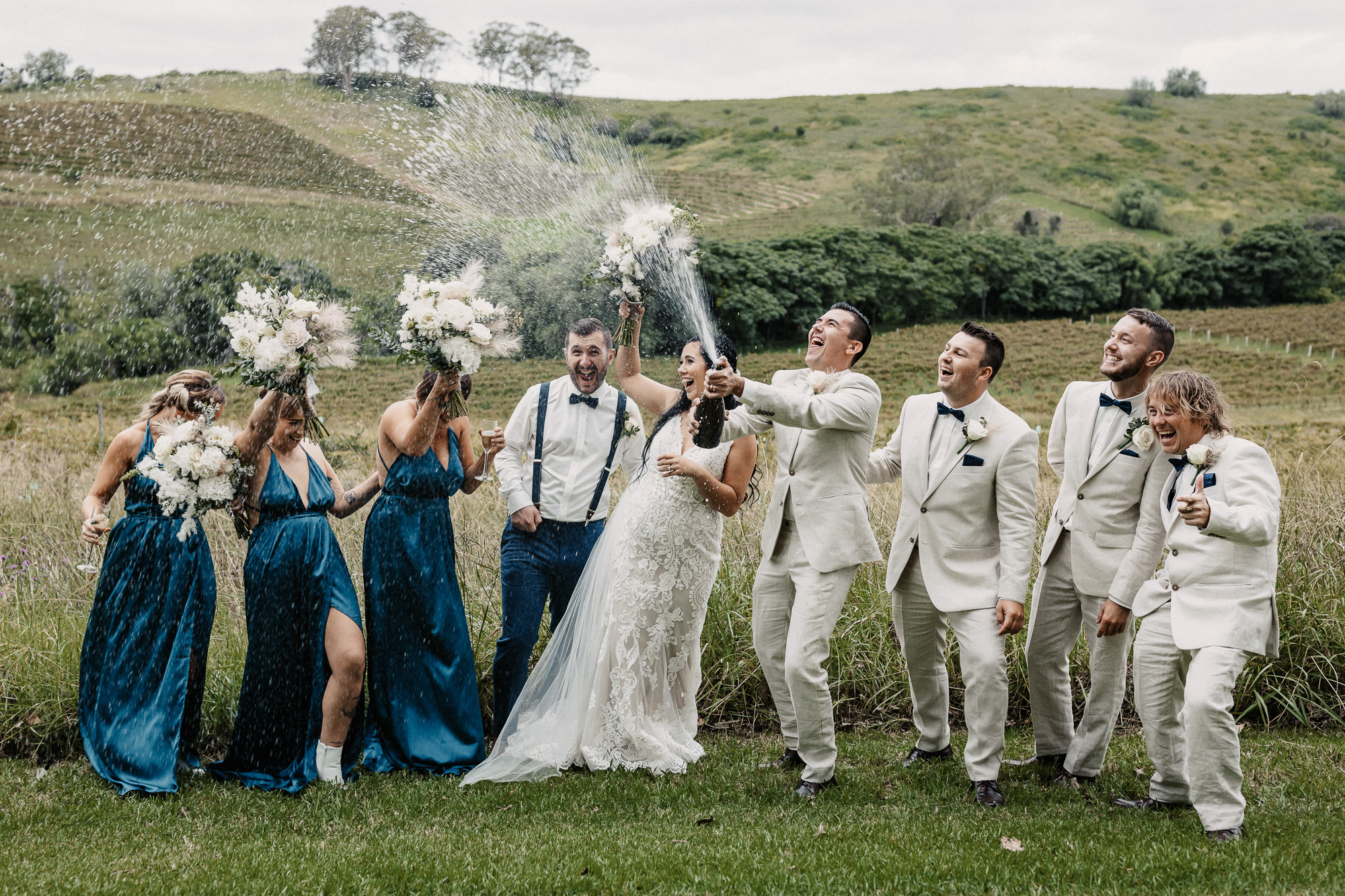 bridal party popping a bottle of champagne in the hunter valley