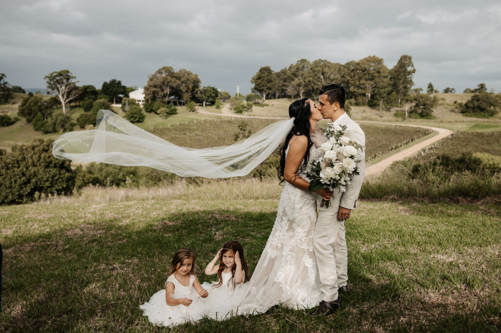 husband and wife kissing with their kids at their feet