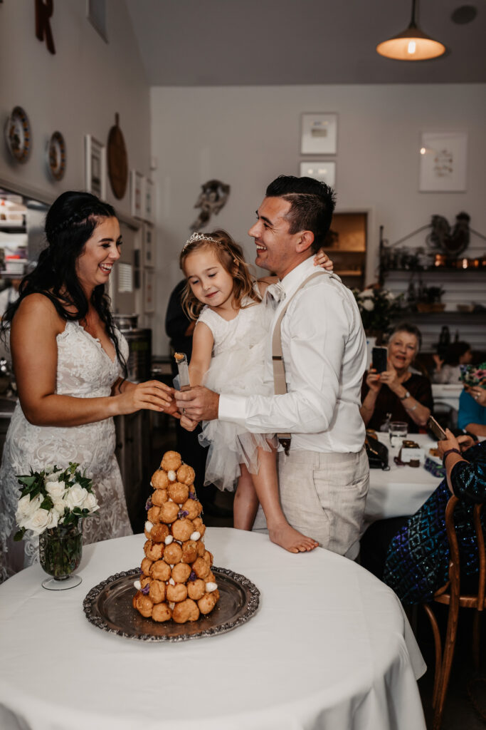 husband and wife about to cut their cake with their daughter