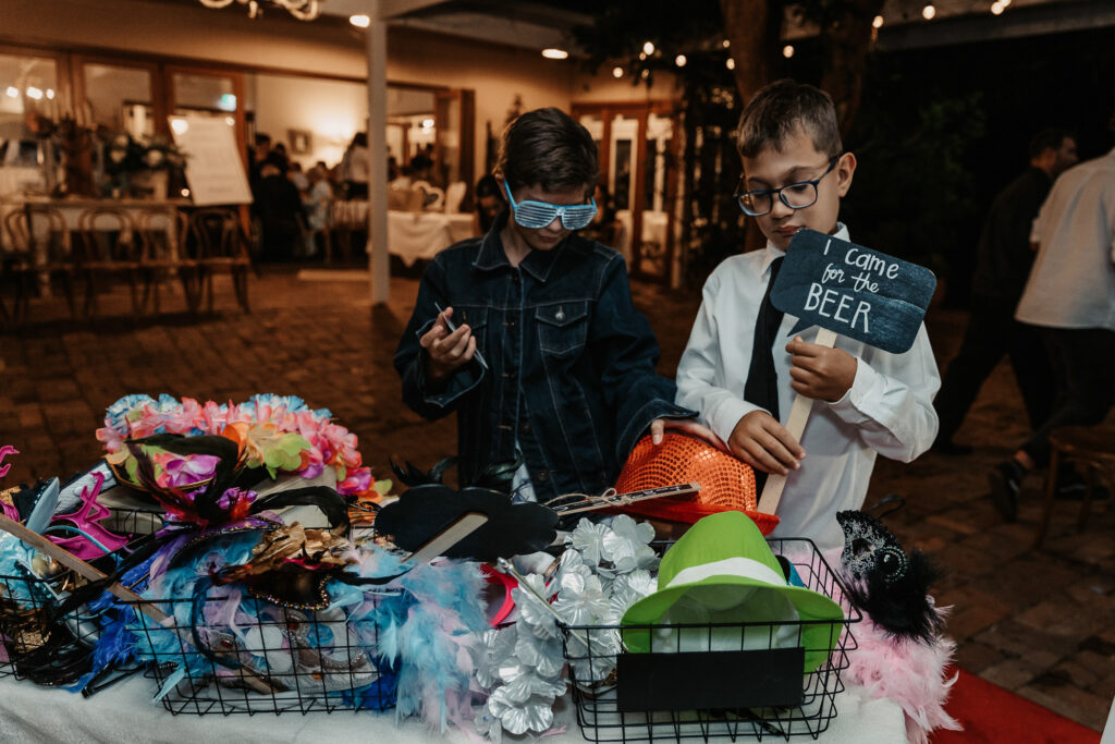 kids at a wedding with their Photo Booth props