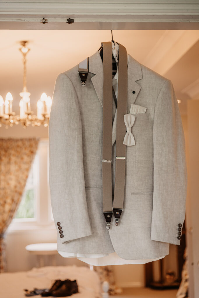 grooms suit hanging up on the door way