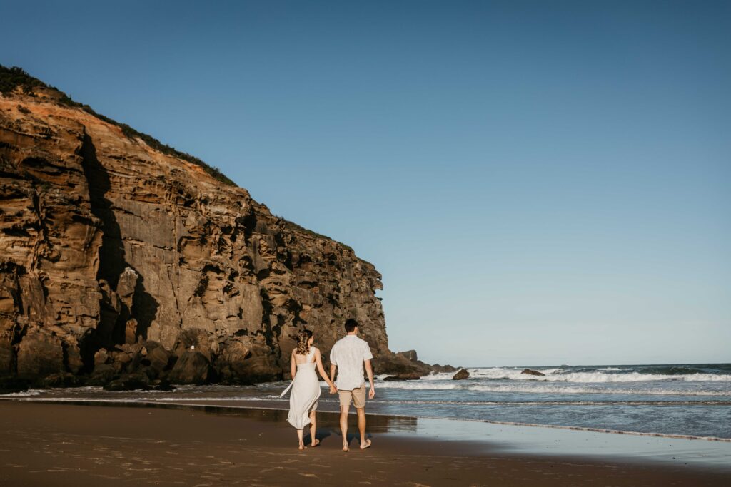 Couple walking together on redhead beach