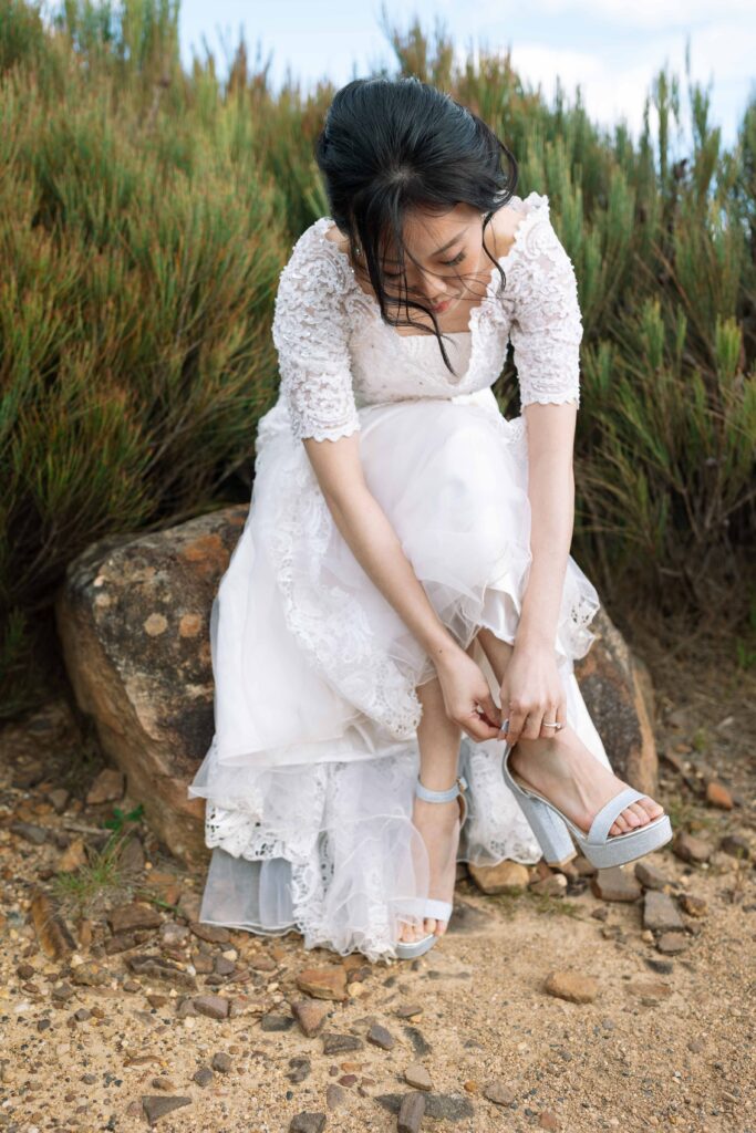 Fiancé putting her shoes on at the top of the blue mountains