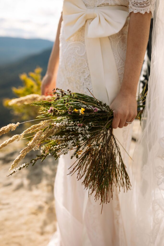 Native flowers in a brides hand at the top of the blue mountains