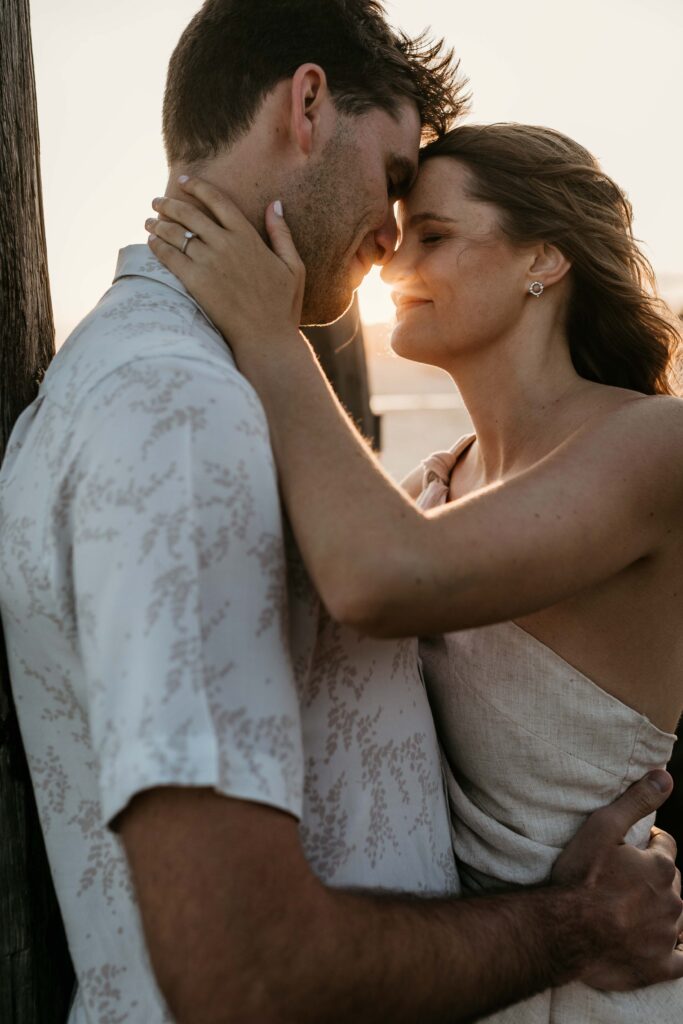 Couple kissing at Sunset Engagement Session on Redhead beach, NSW