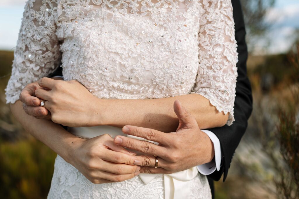 couple placing each others wedding rings on