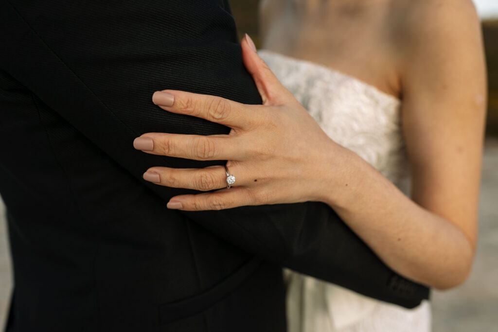 Engagement ring on her hand on him