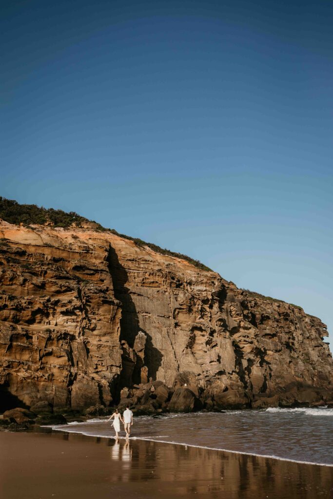 Couple walking together on redhead beach