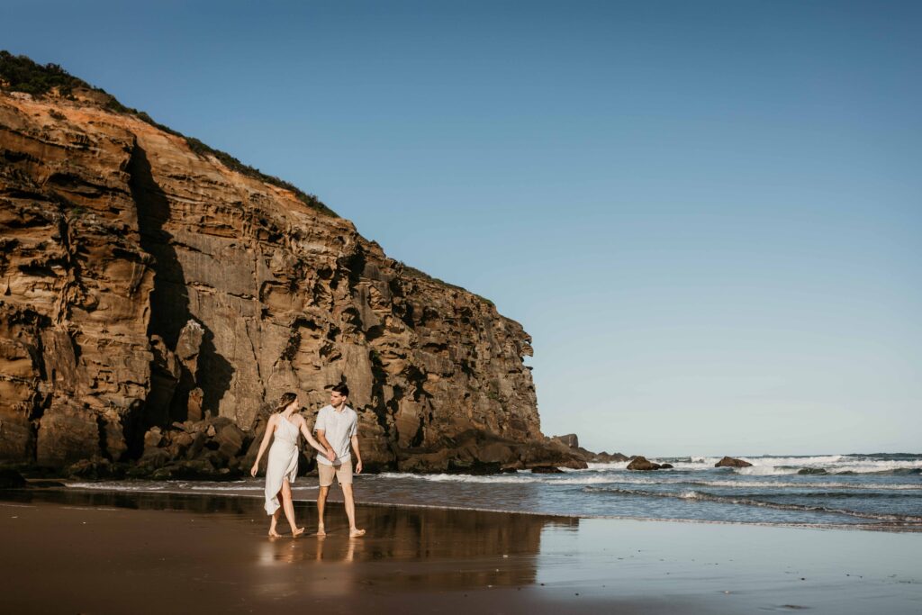 Couple walking together on redhead beach
