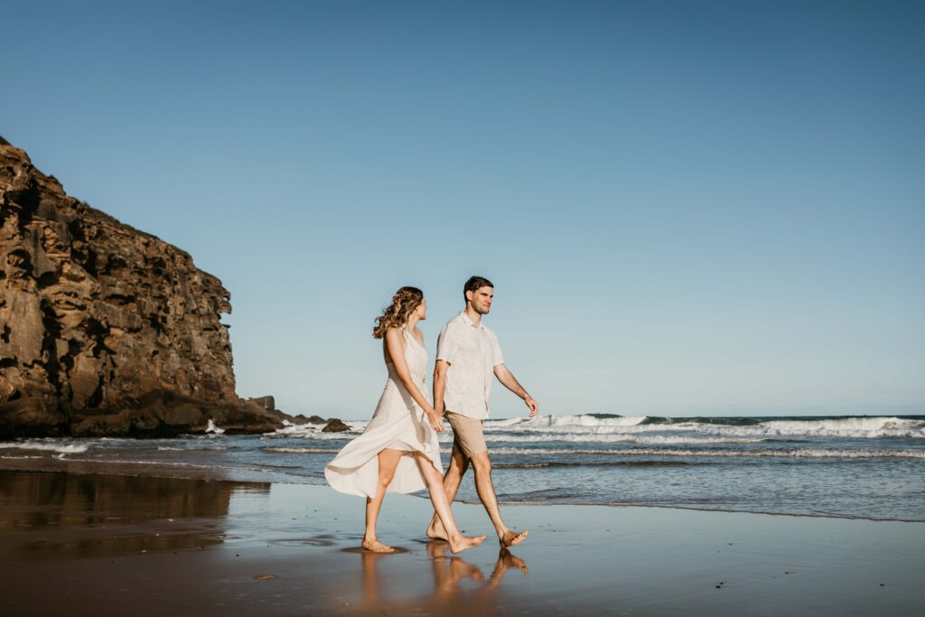 Couple walking together on redhead beach